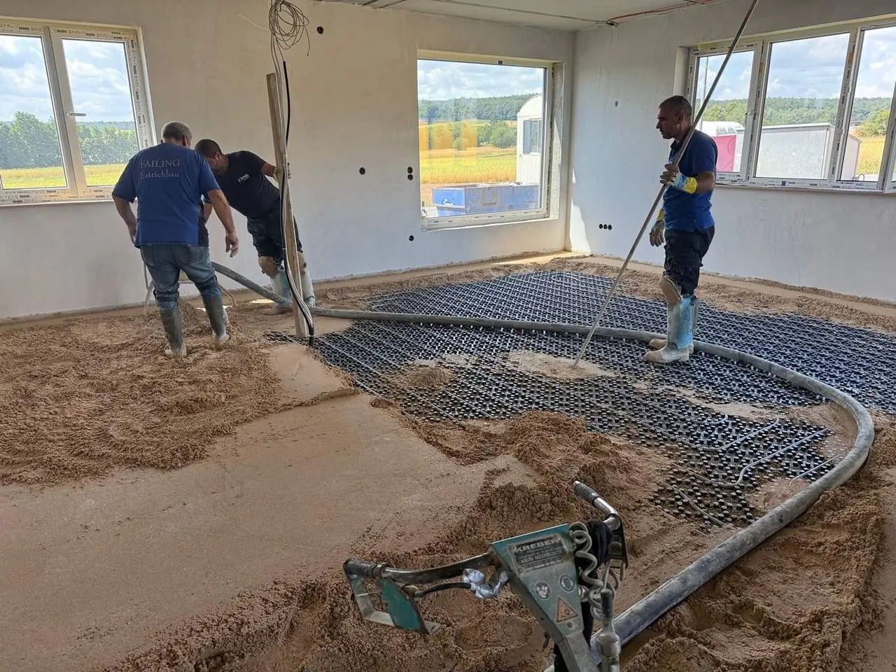 Drei Mitarbeiter der Failing GmbH beim Estricheinbau auf einer großen Fläche