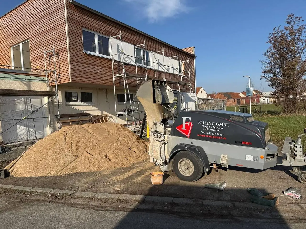 Estrichpumpe vor einem Gebäude mit Holzfassade
